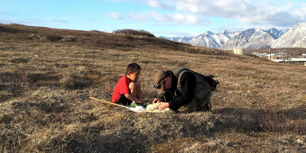 A biologist and young child are collecting field data on Alaska's North Slope.